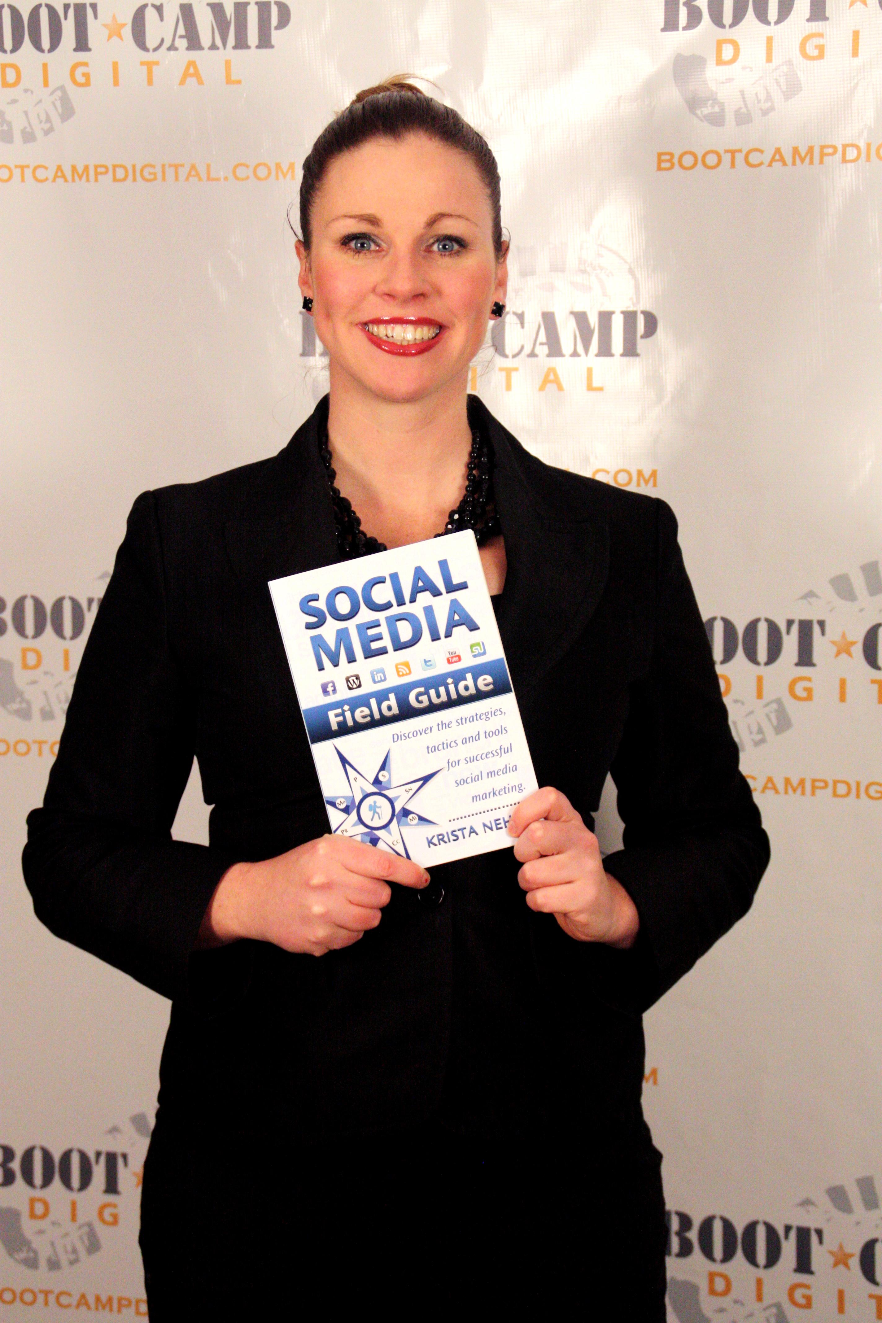 Krista Neher holding her book Social Media Field Guide