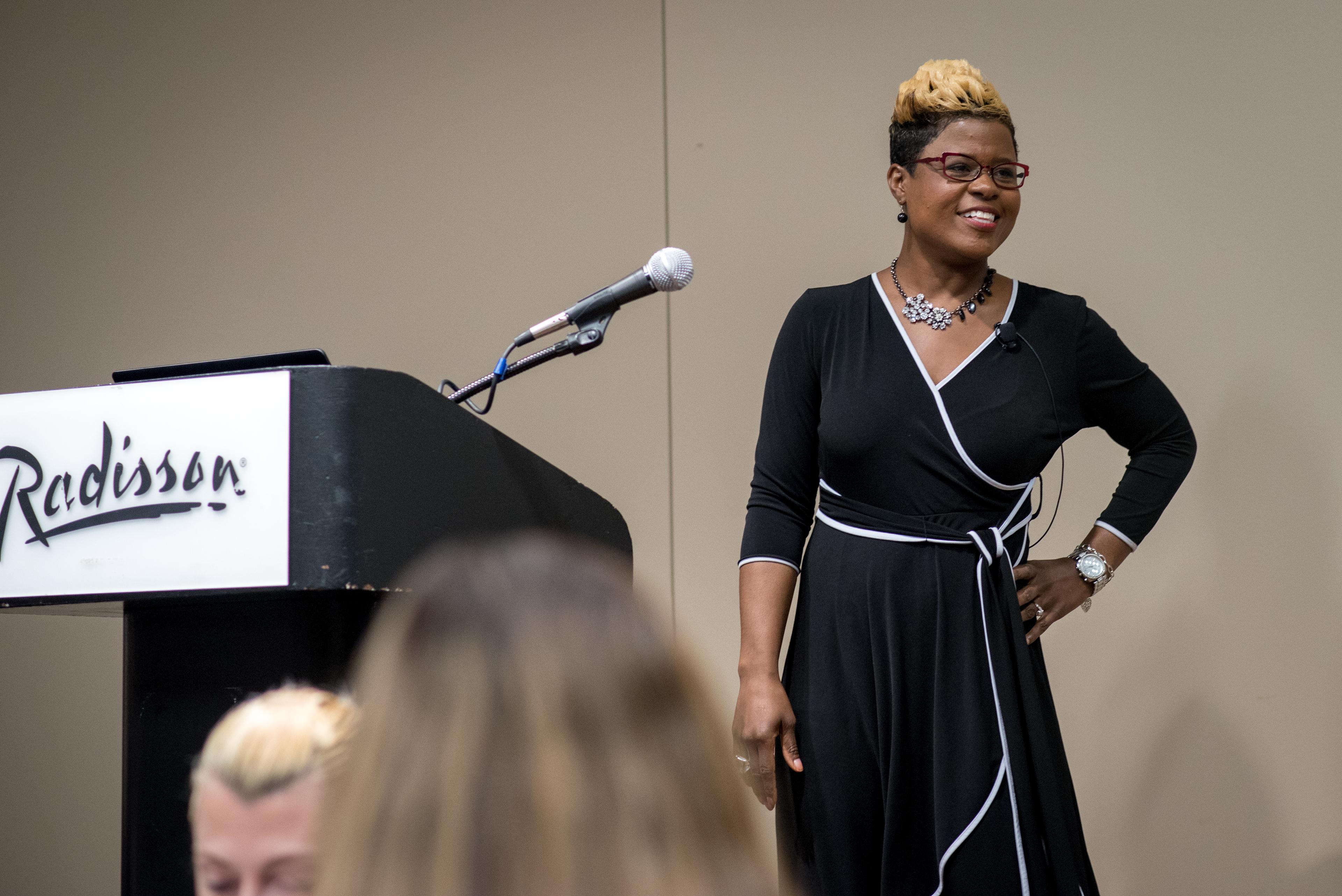 Tiffany Lewis | stage shot | wearing black & white dress | color photo